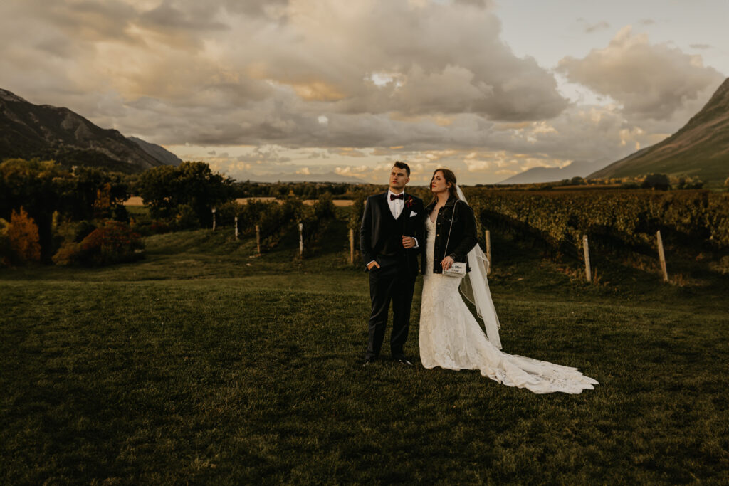 a couple poses in front of a vineyard for their elopement wedding